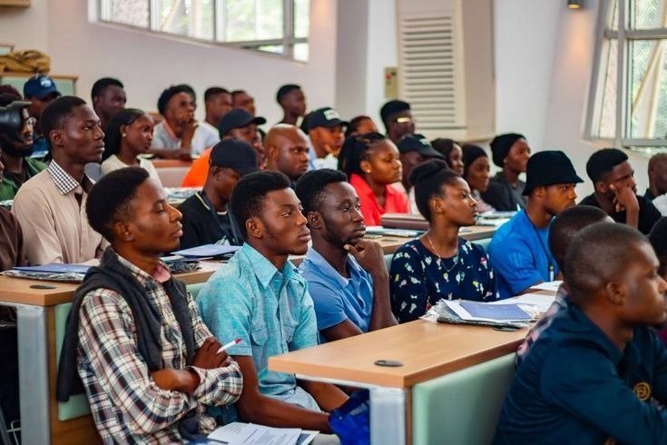 Young people seated at desks in a lecture hall